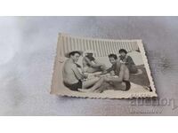 Φωτογραφία Άνδρες και γυναίκες παίζουν χαρτιά στην παραλία