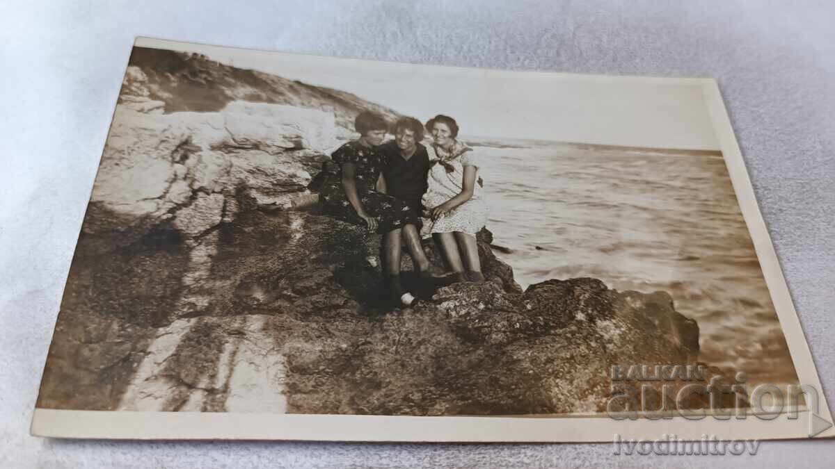 Photo of Anhialo. Three young girls on the rocks above the sea