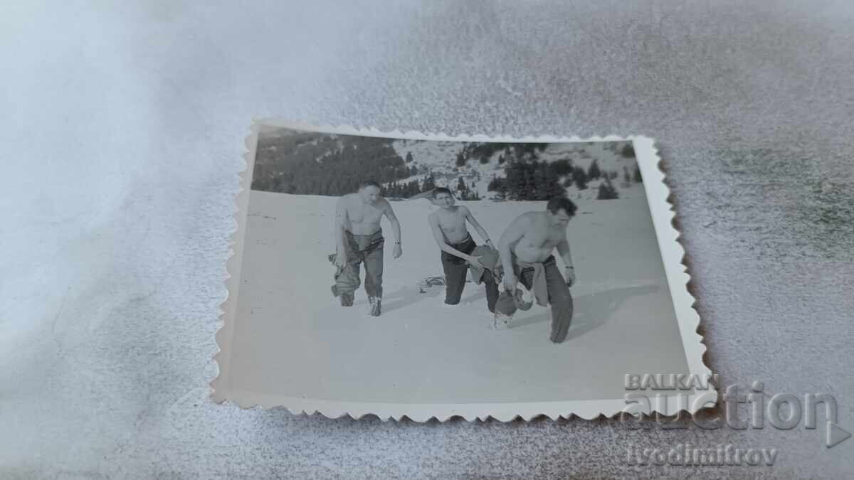 Photo of three men shirtless in the mountains in winter