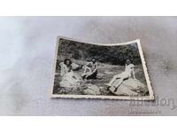 Fotografie: Doi bărbați și o fată șezând pe pietre în râu