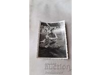 Photo of a Young Person Sitting on a Rock on the Seashore