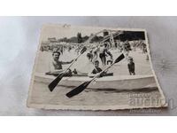 Φωτογραφία Άνδρας και αγόρια με βάρκα στην ακτή της θάλασσας