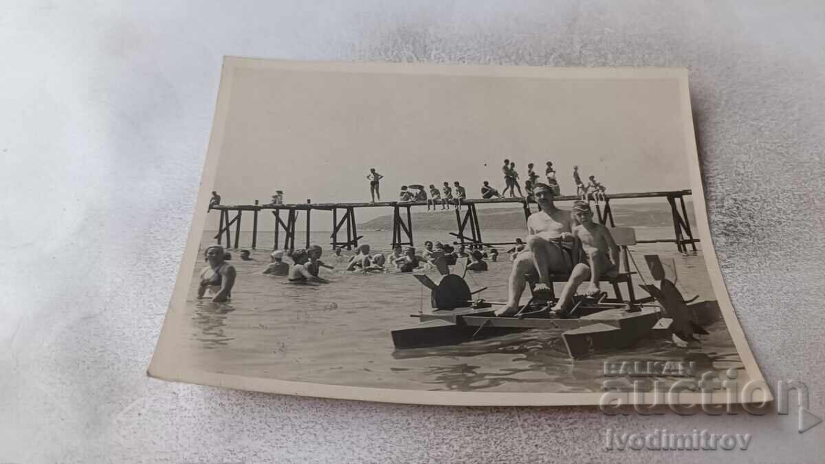 Φωτογραφία Άνδρας και αγόρι με θαλάσσιο ποδήλατο στη θάλασσα