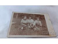 Photo of three young girls sitting on the grass