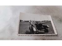 Photo of a Boy Sitting on a Cannon Tire