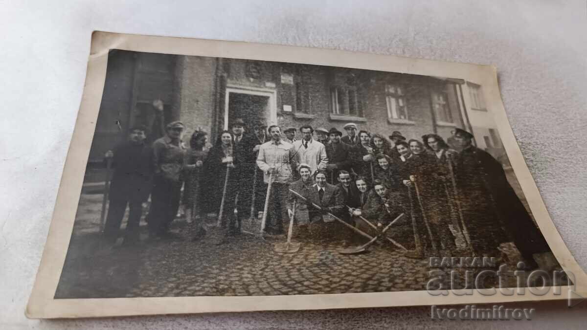 Φωτογραφία Άνδρες και γυναίκες με φτυάρια στον δρόμο