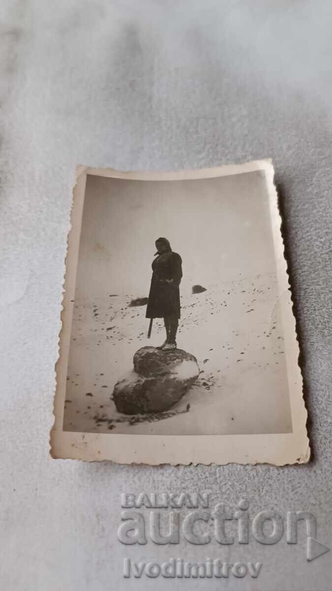 Photo of a woman climbing on a rock in winter