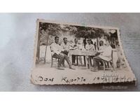 Photo: Men sitting around a table, having a drink