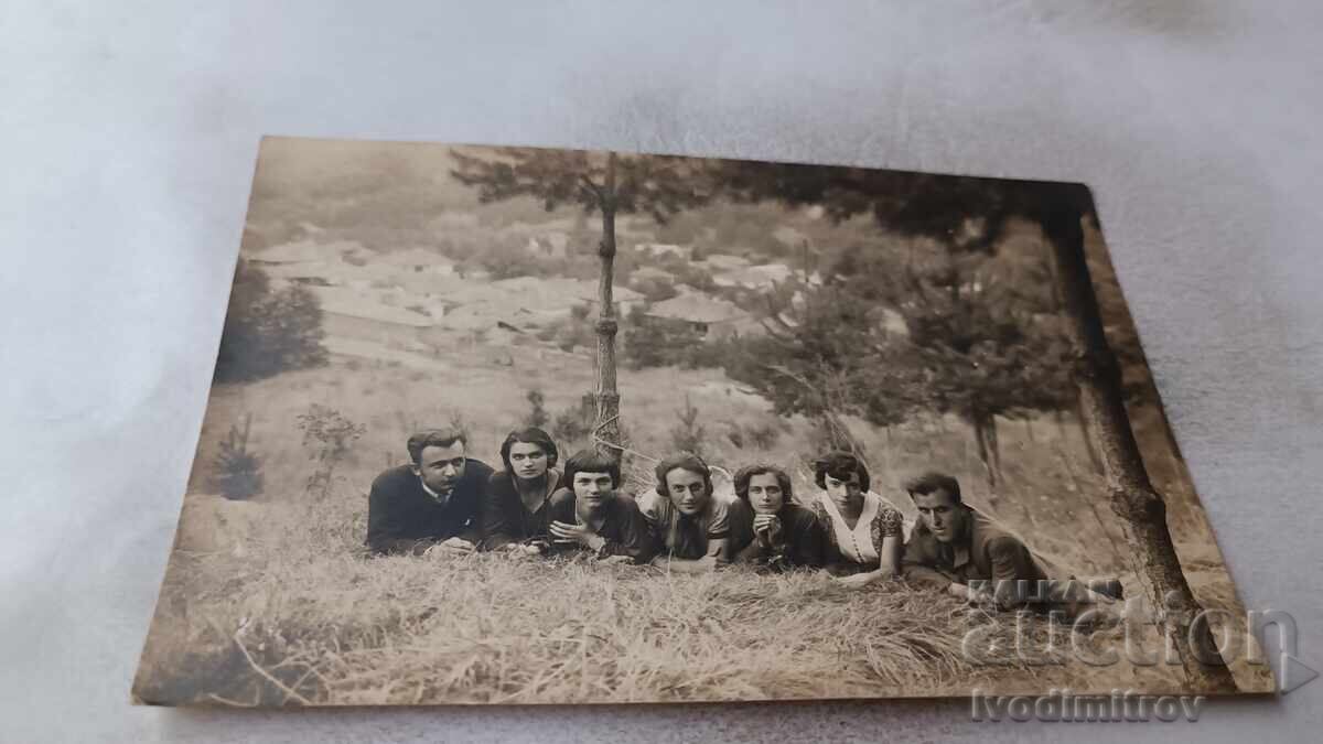 Φωτογραφία Νέων και κοριτσιών ξαπλωμένων στο γρασίδι στο δάσος