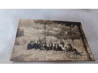 Photo of Young Men and Women Lying on Grass in the Forest
