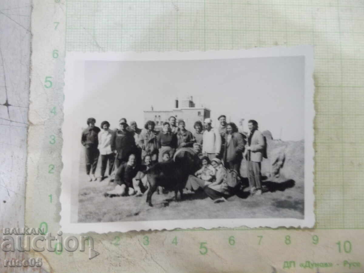 Photo of a group of tourists in front of a meteorological station Photo of a group of tourists in front of a meteorological station