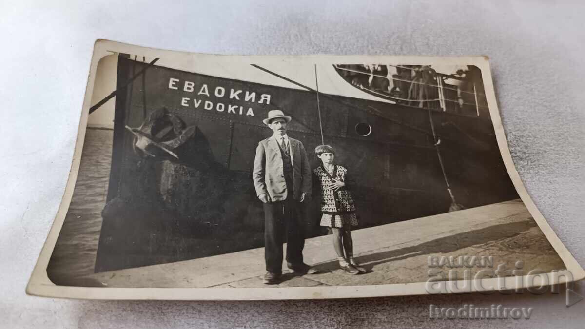 Photo of a Man and a Girl at the Port in front of the Steamer Evdokia Photo of a Man and a Girl at the Port in front of the Steamer Evdokia