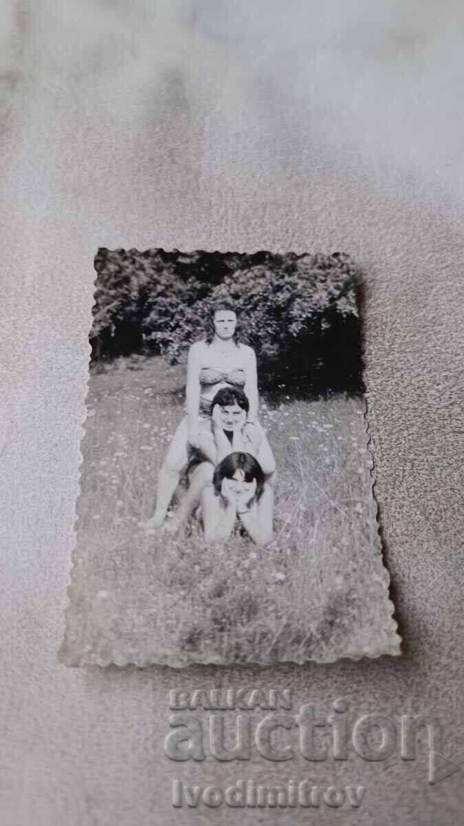 Fotografie Trei fete tinere în costume de baie pe pajiște