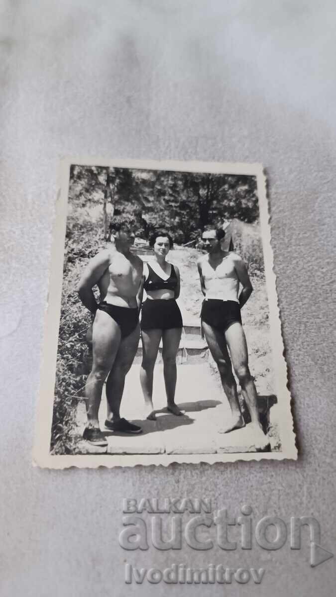 Fotografie Doi bărbați și o femeie în costume de baie pe potecă Fotografie Doi bărbați și o femeie în costume de baie pe potecă