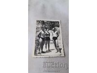 Fotografie Doi bărbați și o femeie în costume de baie pe potecă