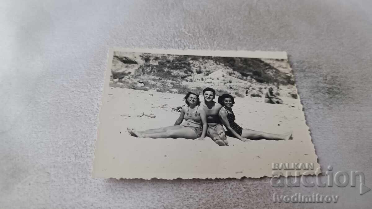 Φωτογραφία Ένας νεαρός άνδρας και δύο κορίτσια στην παραλία