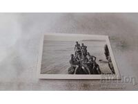 Fotografie Bărbați femei și copii pe stâncă pe malul mării