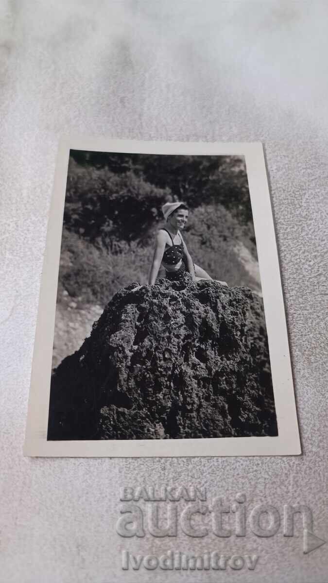 Φωτογραφία Νέο κορίτσι που κάθεται σε βράχο