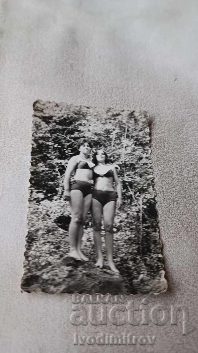 Φωτογραφία Δύο νεαρών κοριτσιών με μαγιό σε βράχο