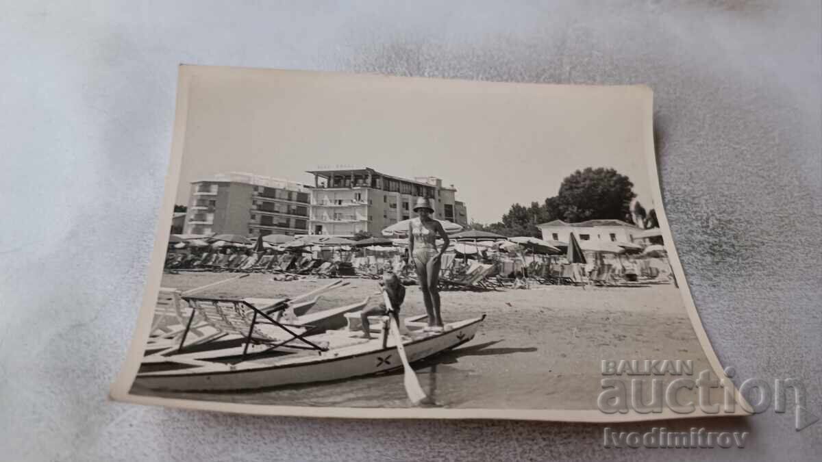 Fotografie: Femeie și băiețel într-o barcă pe malul mării