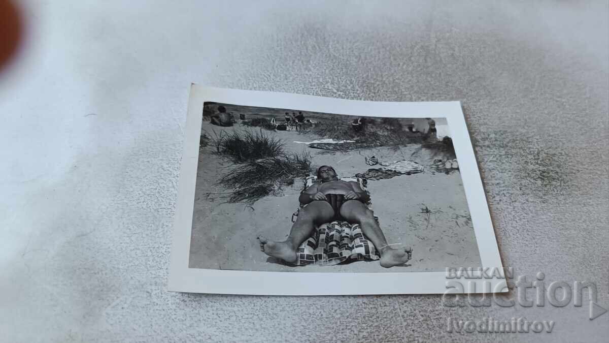 Fotografie Kranevo Bărbat întins pe saltea gonflabilă pe dune