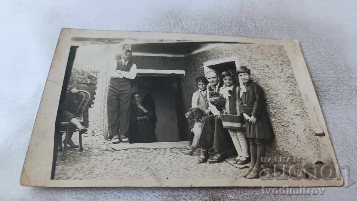 Снимка Мъже деца и куче в двора на къща