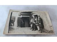 Fotografie cu bărbați, copii și câine în curtea casei