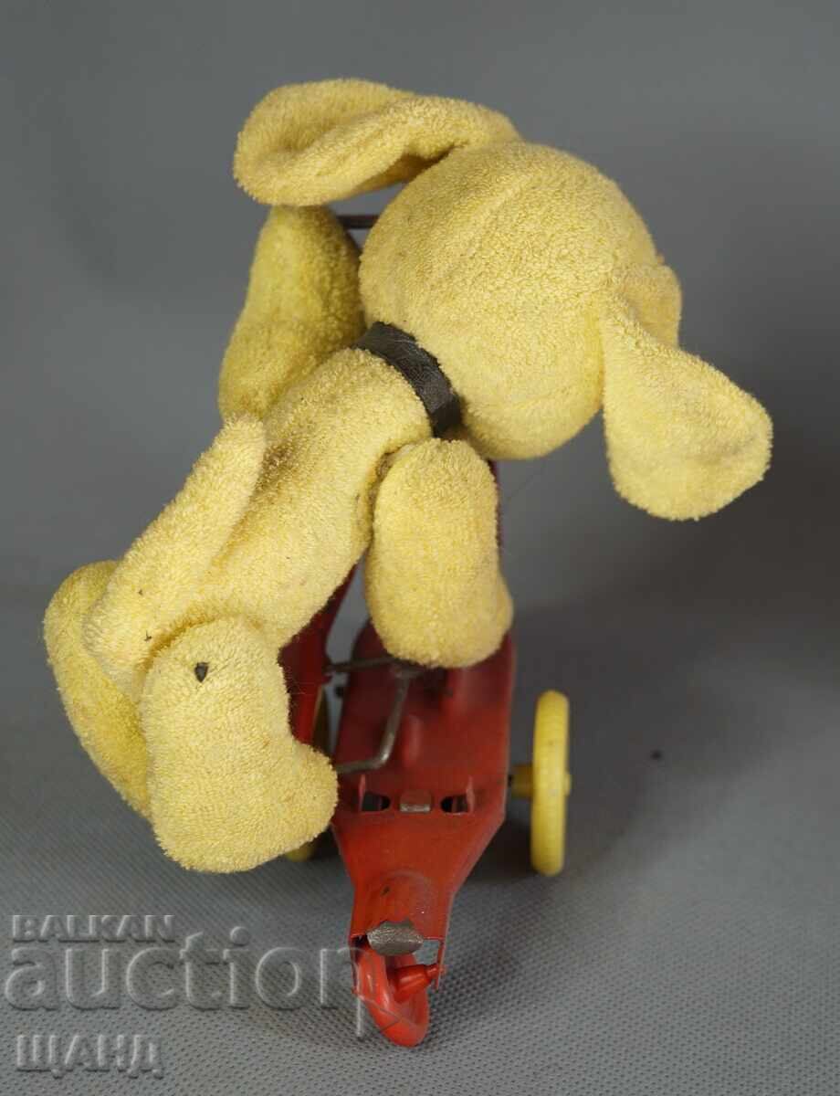 Delivery of Old mechanical metal toy scooter model with dog