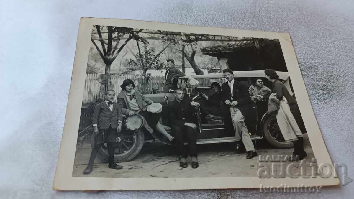 Φωτογραφία Νέοι άνδρες και γυναίκες με ένα vintage αυτοκίνητο