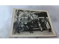 Φωτογραφία Νέοι άνδρες και γυναίκες με ένα vintage αυτοκίνητο