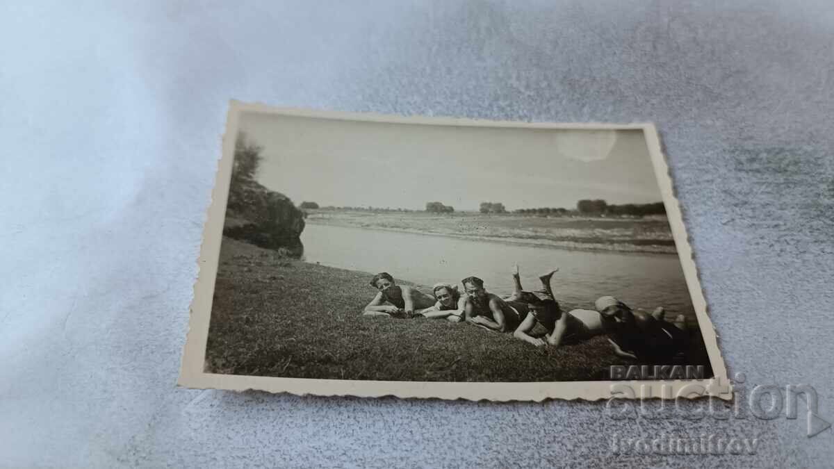 Fotografie Tineri și tinere cu costume de baie retro întinși lângă râu