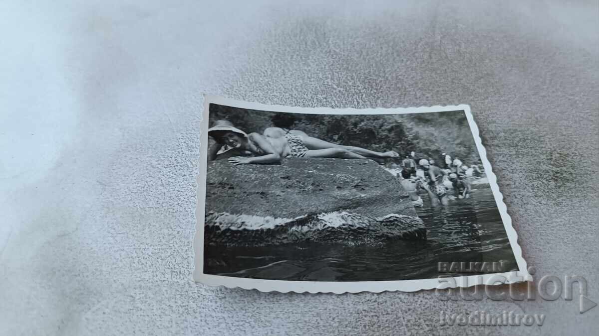 Φωτογραφία Νέας Γυναίκας Ξαπλωμένης σε Βράχο στη Θάλασσα