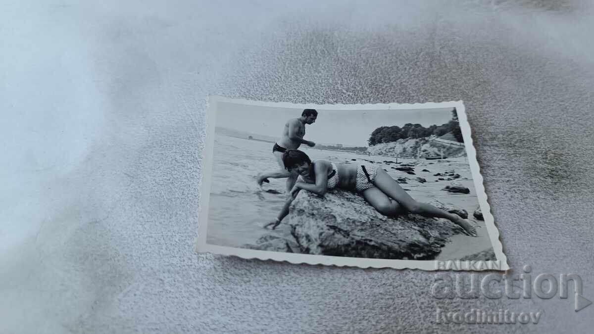 Φωτογραφία Νέας Γυναίκας Ξαπλωμένης σε Βράχο Δίπλα στη Θάλασσα