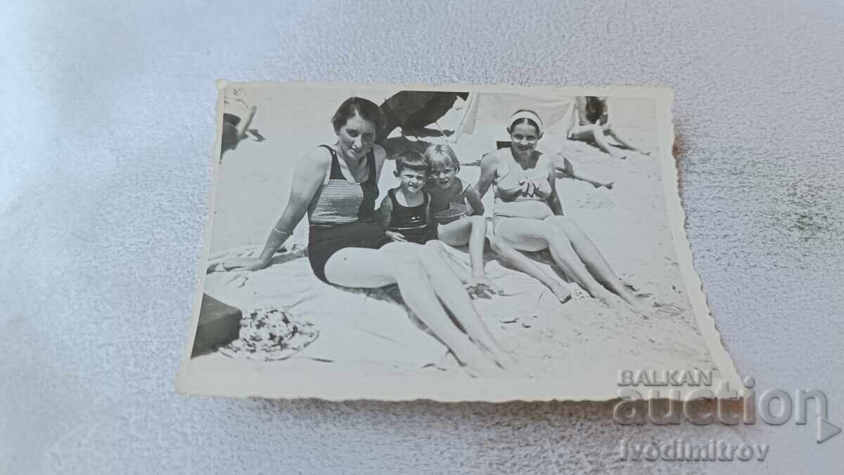 Снимка Жена младо момиче и две деца на плажа Снимка Жена младо момиче и две деца на плажа