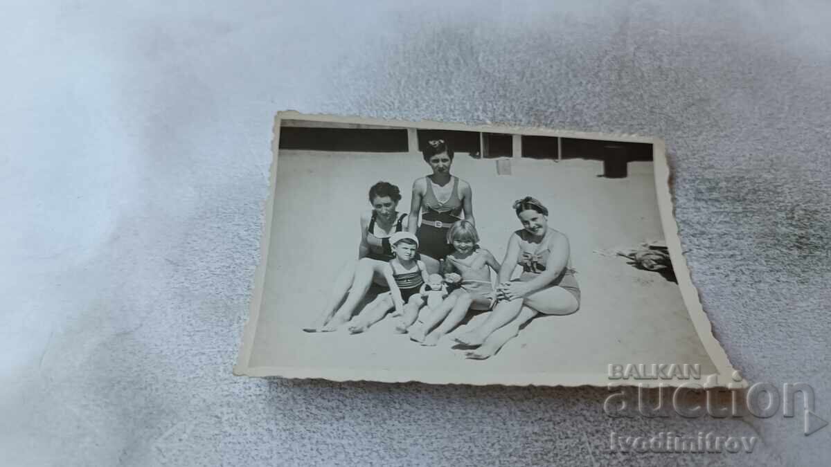 Fotografie Femeie tânără și doi copii pe plajă