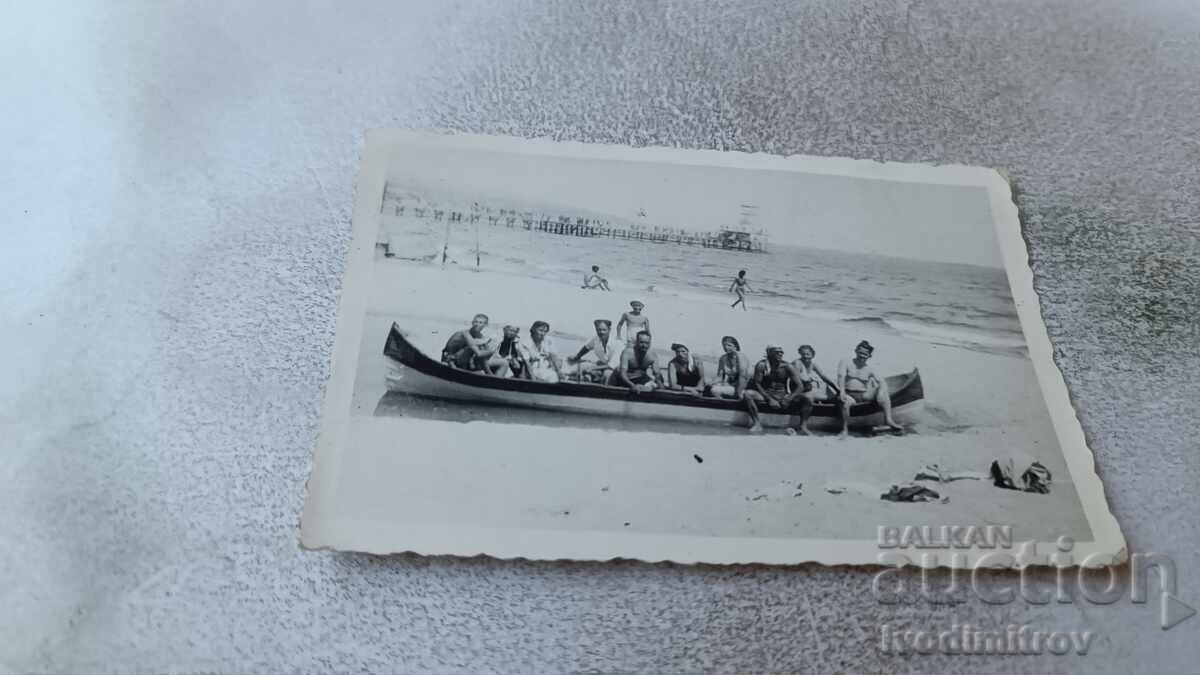 Φωτογραφία Άνδρες και γυναίκες σε βάρκα στην παραλία