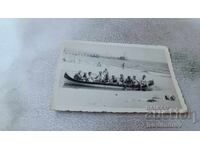 Снимка Мъже и жени в лодка на плажа