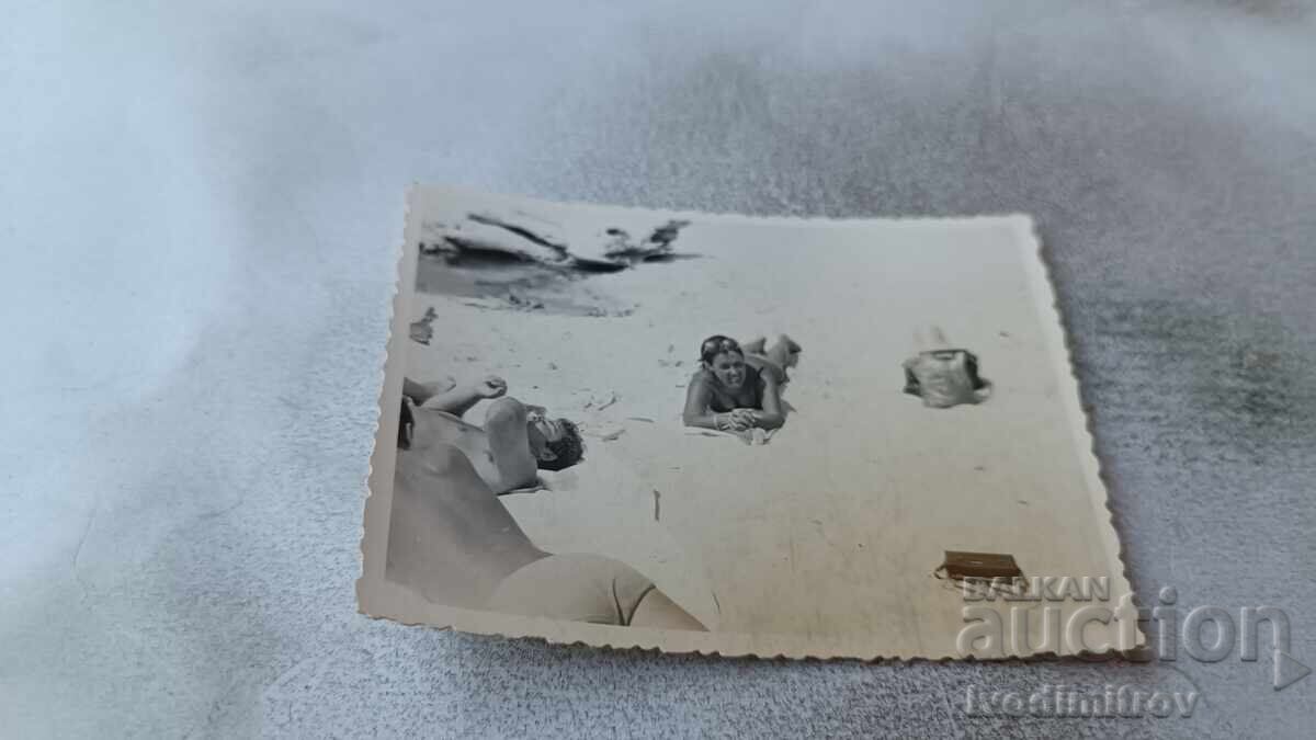 Fotografie cu o femeie culcată pe burtă pe plajă