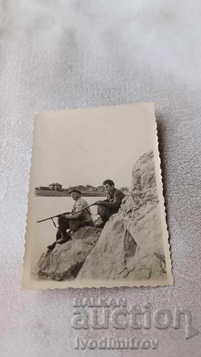 Photograph of Two Hunters by a Lake