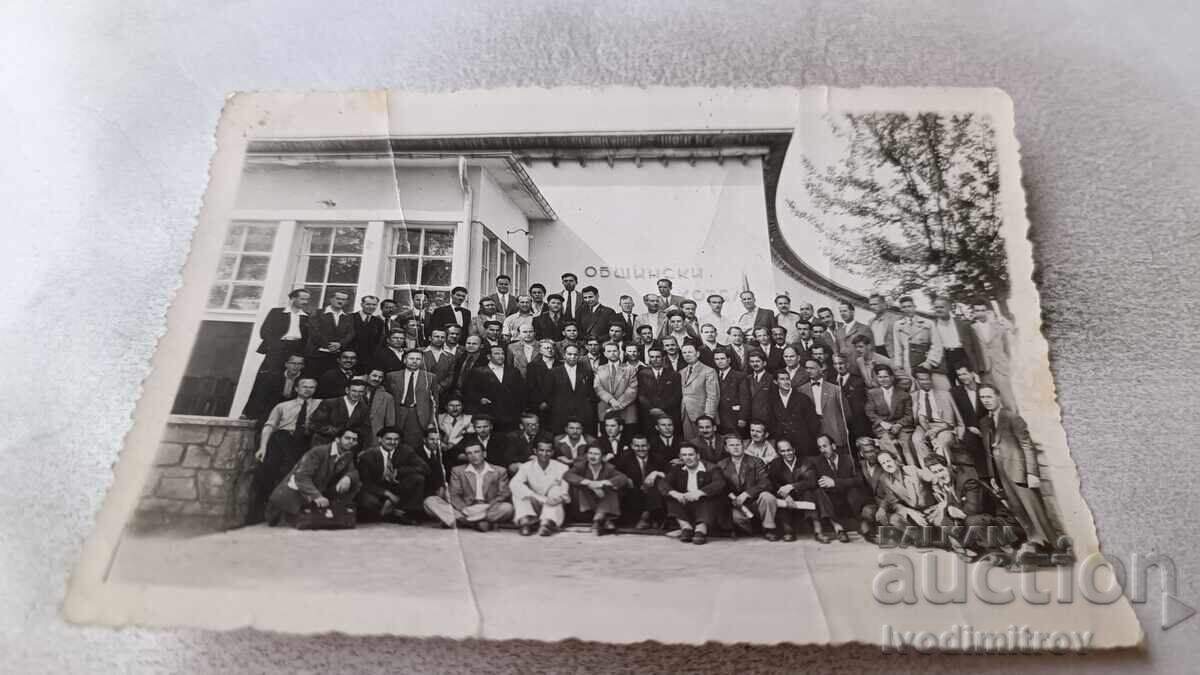 Φωτογραφία Άνδρες μπροστά από Δημοτικό Ξενοδοχείο