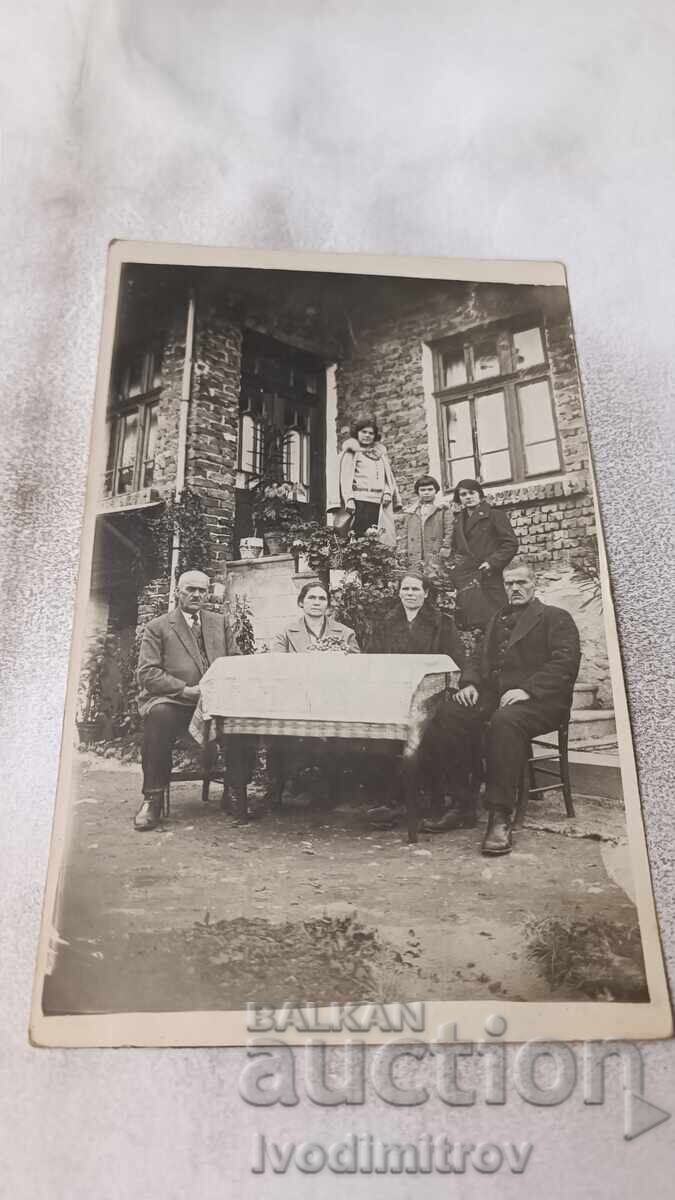 Φωτογραφία Άνδρες και γυναίκες στο τραπέζι μπροστά από το σπίτι τους Φωτογραφία Άνδρες και γυναίκες στο τραπέζι μπροστά από το σπίτι τους