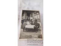 Φωτογραφία Άνδρες και γυναίκες στο τραπέζι μπροστά από το σπίτι τους