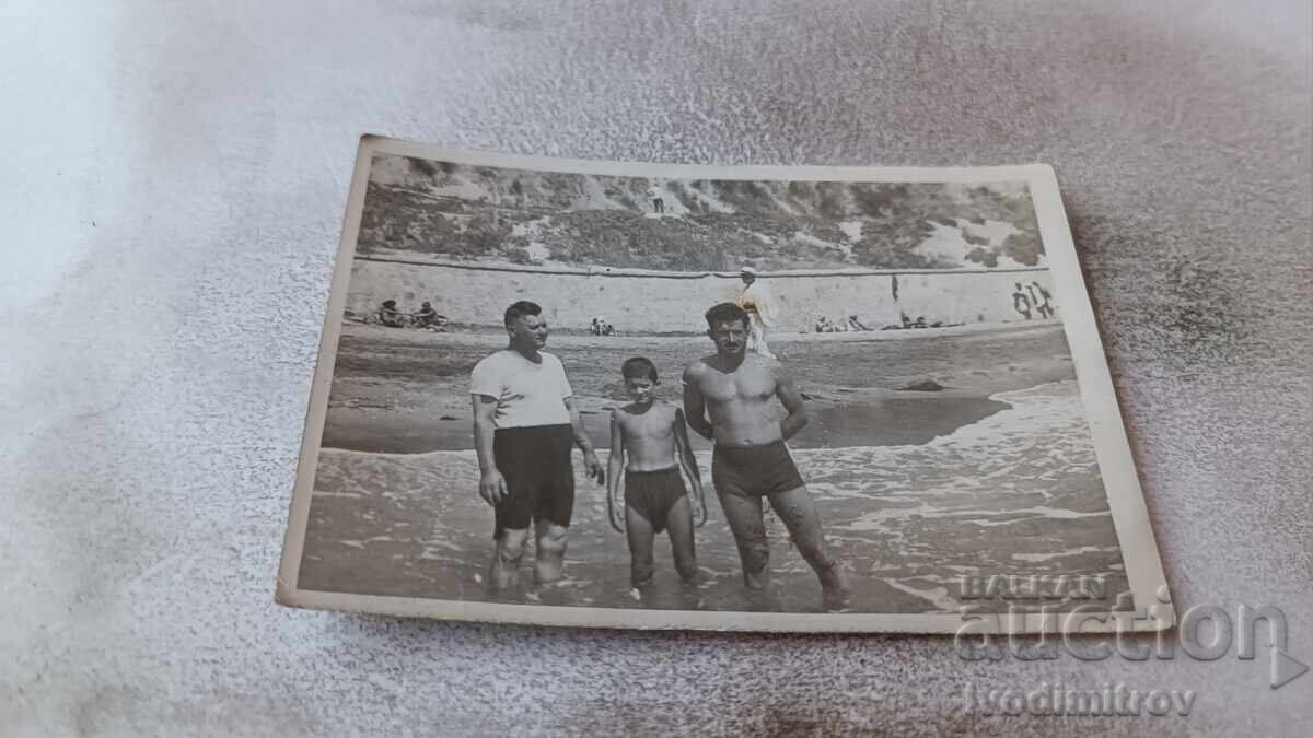 Снимка Двама мъже и момче на брега на морето
