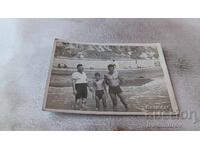 Снимка Двама мъже и момче на брега на морето