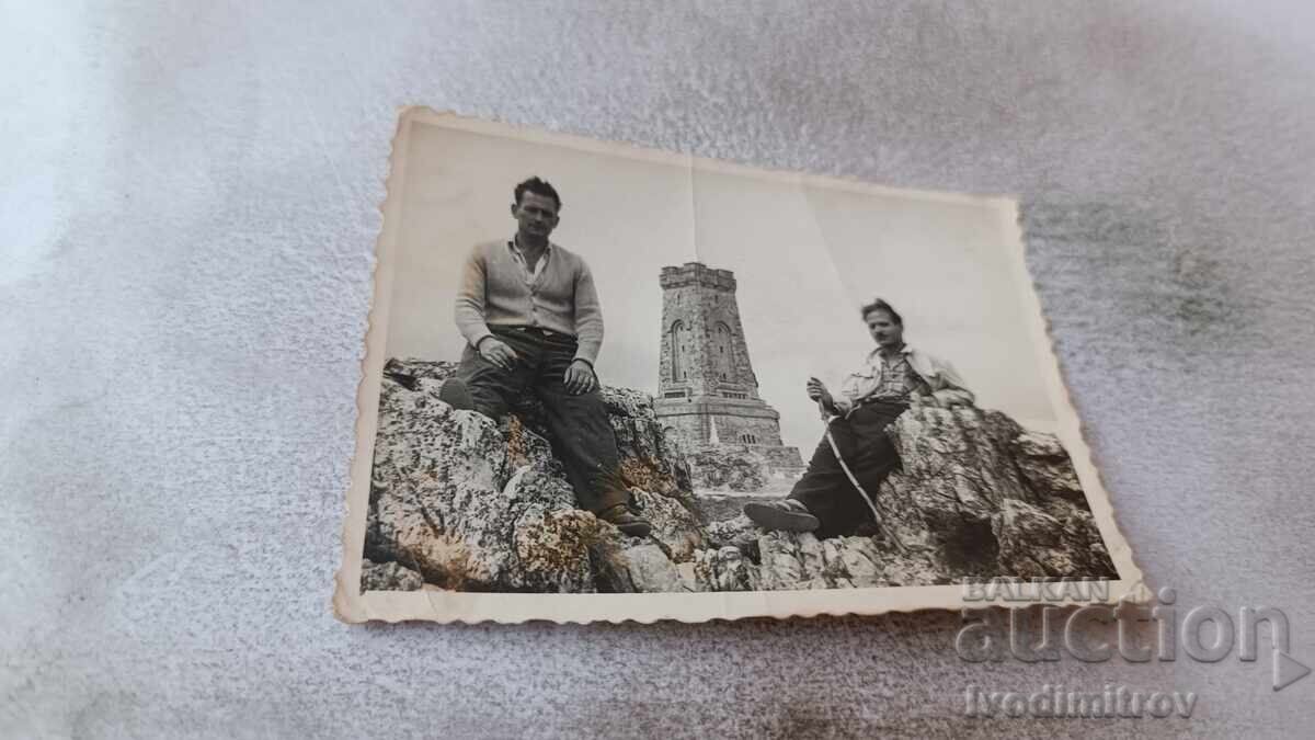 Φωτογραφία Δύο ανδρών σε βράχους μπροστά από το μνημείο Σίπκα