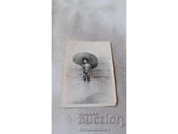 Photo of a little girl with a sombrero on the seashore