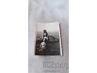 Photo of Two Men and a Little Girl on a Cliff by the Sea