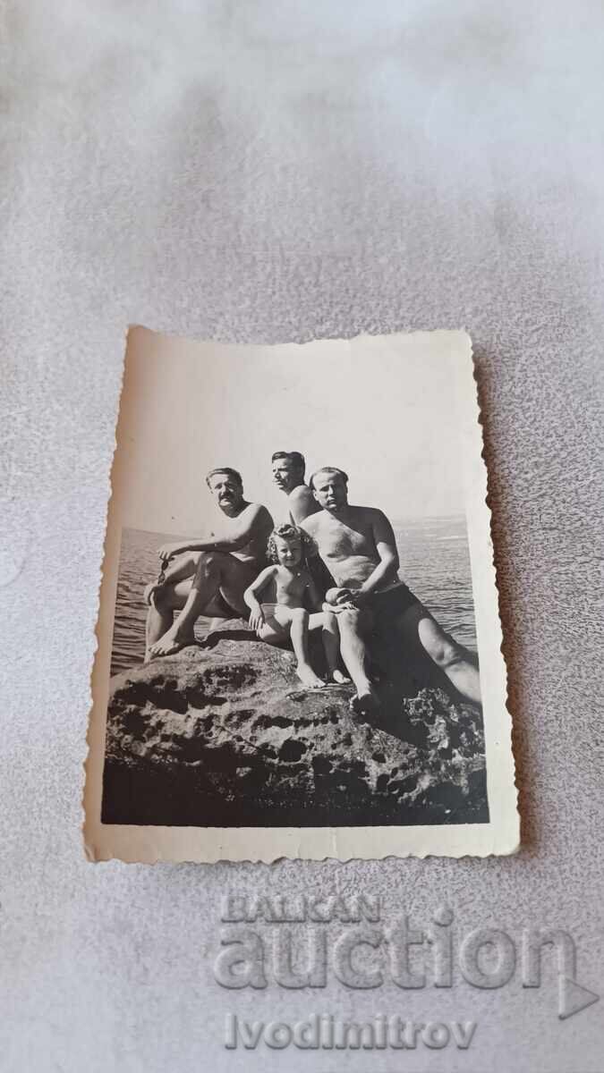 Φωτογραφία Άνδρες και μικρό κοριτσάκι σε βράχο στη θάλασσα