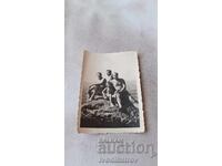 Fotografie cu bărbați și o fetiță pe o stâncă în mare