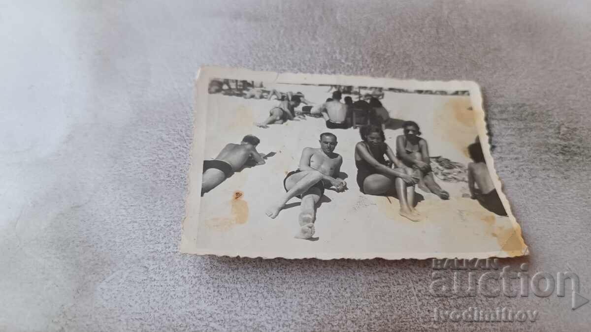 Fotografie Un tânăr și două fete tinere pe plajă